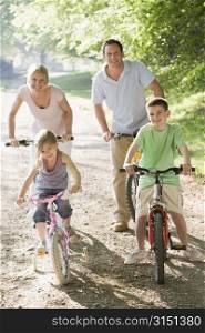 Family on bikes on path smiling