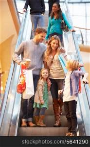 Family On Escalator In Shopping Mall Together