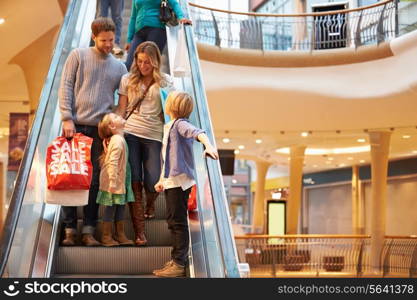 Family On Escalator In Shopping Mall Together