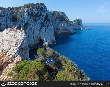 Family on rocky south cape of Lefkas island and lighthouse (Greece, Ionian Sea)