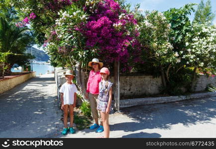 Family on street with blossoming tree in Assos village (Greece, Kefalonia)