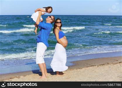 Family on the beach shore pregnant mother