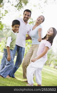 Family outdoors in park bonding and smiling (selective focus)