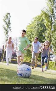 Family outdoors playing soccer and having fun