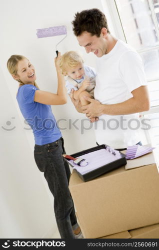 Family painting room in new home smiling