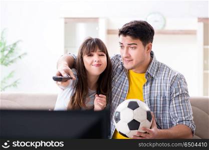 Family pair watching football at home