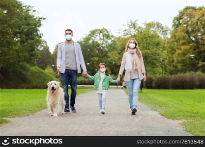 family, pandemic and health concept - mother, father and little daughter wearing face protective medical mask for protection from virus disease with labrador retriever dog walking in summer park. family in masks with labrador dog in park