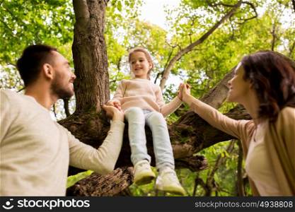 family, parenthood, adoption and people concept - happy mother, father and little girl in summer park having fun. happy family in summer park having fun