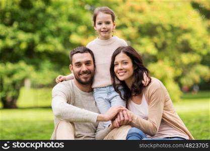 family, parenthood, adoption and people concept - happy mother, father and little girl in summer park