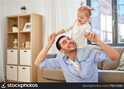 family, parenthood and fatherhood concept - happy father riding little baby daughter on his neck at home. father riding little baby daughter on neck at home