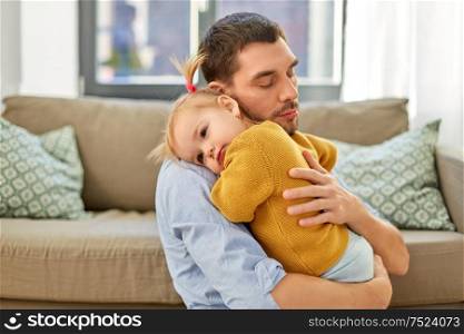 family, parenthood and fatherhood concept - loving father holding little baby daughter at home. loving father holding baby daughter at home