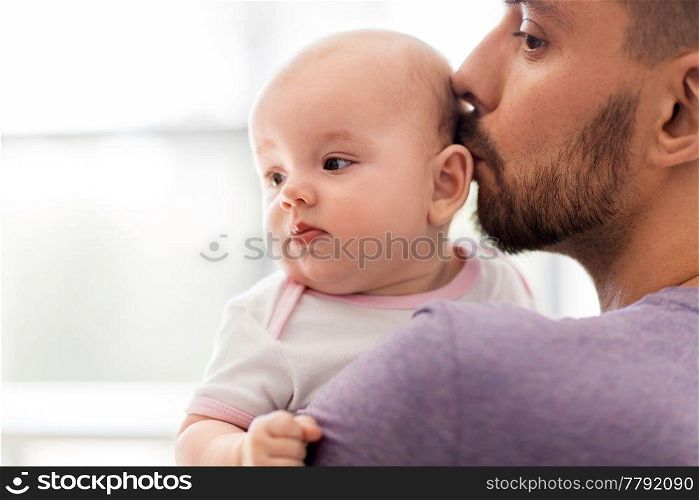 family, parenthood and people concept - close up of father kissing little baby daughter. close up of father kissing little baby daughter