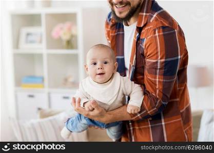 family, parenthood and people concept - close up of happy father playing with little baby boy at home. happy father with little baby boy at home