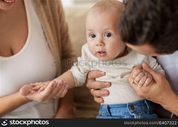 family, parenthood and people concept - close up of happy mother, father with baby at home. close up of happy family with baby at home