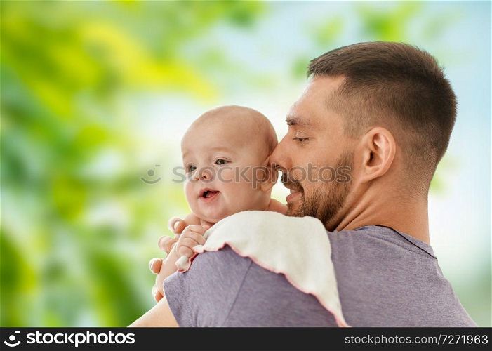 family, parenthood and people concept - father with little baby daughter over green natural background. father with little baby over natural background