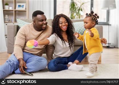 family, parenthood and people concept - happy african american mother and father playing with baby daughter at home. african family playing with baby daughter at home