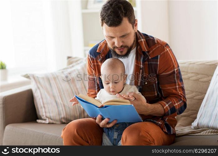 family, parenthood and people concept - happy father and little baby boy with book at home. happy father and little baby boy with book at home
