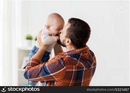 family, parenthood and people concept - happy father kissing little baby boy at home. happy father kissing little baby boy at home