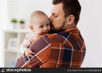 family, parenthood and people concept - happy father kissing little baby boy at home. happy father kissing little baby boy at home