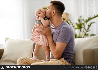 family, parenthood and people concept - happy father kissing little baby daughter. father kissing little baby daughter