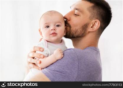 family, parenthood and people concept - happy father kissing little baby daughter. father kissing little baby daughter