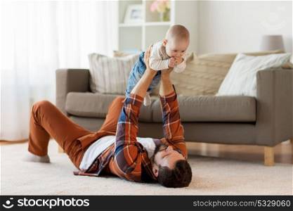 family, parenthood and people concept - happy father playing with little baby boy at home. happy father with little baby boy at home
