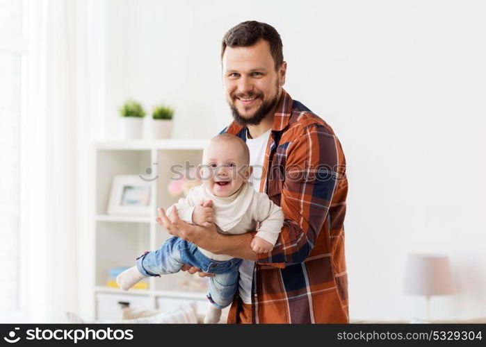 family, parenthood and people concept - happy father playing with little baby boy at home. happy father with little baby boy at home