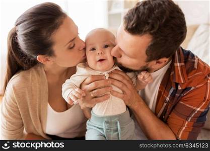 family, parenthood and people concept - happy mother and father kissing little baby at home. happy mother and father kissing baby at home