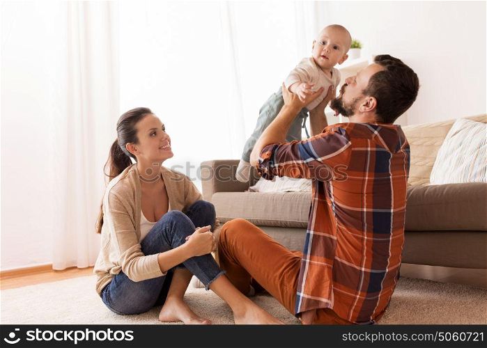 family, parenthood and people concept - happy mother and father playing with baby at home. happy mother and father playing with baby at home