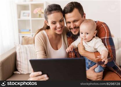 family, parenthood and people concept - happy mother and father showing tablet pc computer to baby at home. mother, father and baby with tablet pc at home