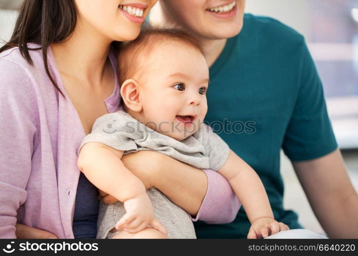 family, parenthood and people concept - happy mother and father with baby boy at home. happy family with baby boy at home