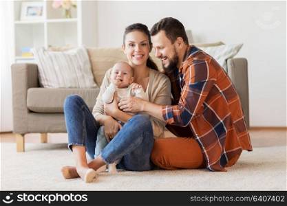 family, parenthood and people concept - happy mother, father and baby at home. happy family with baby at home