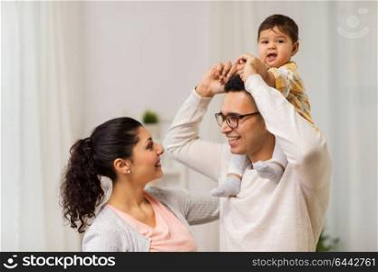 family, parenthood and people concept - happy mother, father and baby daughter playing at home. happy family and baby daughter playing at home