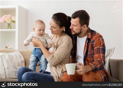 family, parenthood and people concept - happy mother, father with baby at home. happy family with baby at home