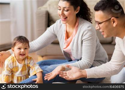 family, parenthood and people concept - happy mother, father with baby daughter at home. happy family with baby daughter at home