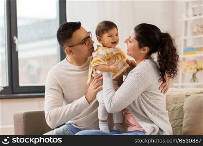 family, parenthood and people concept - happy mother, father with baby daughter at home. happy family with baby daughter at home. happy family with baby daughter at home