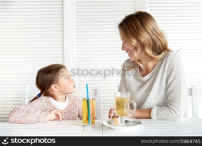 family, parenthood, communication and people concept - happy mother and little girl having dinner and talking at restaurant or cafe