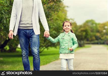 family, parenthood, fatherhood, adoption and people concept - close up of father and happy little girl walking in summer park. close up of father and little girl walking in park