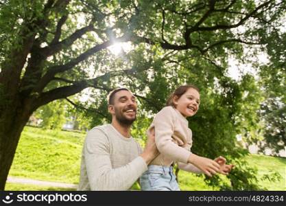 family, parenthood, fatherhood and people concept - happy father and little girl having fun in summer park
