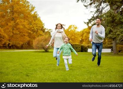 family, parenthood, leisure and people concept - happy mother, father and little girl running and playing catch game in autumn city park