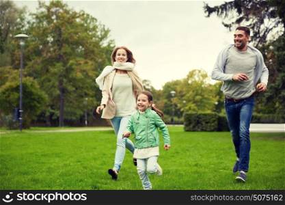 family, parenthood, leisure and people concept - happy mother, father and little girl running and playing catch game in summer park. happy family walking in summer park