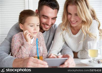 family, parenthood, technology and people concept - happy mother, father and little girl with smartphone having dinner at restaurant