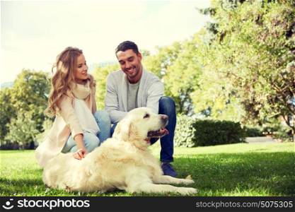 family, pet, animal and people concept - happy couple with labrador retriever dog walking in city park. happy couple with labrador dog walking in city