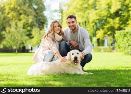 family, pet, animal and people concept - happy couple with labrador retriever dog walking in city park