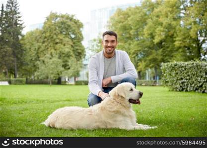 family, pet, animal and people concept - happy man with labrador retriever dog walking in city park