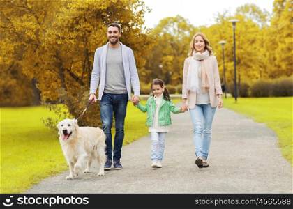 family, pet, domestic animal and people concept - happy family with labrador retriever dog walking in autumn city park