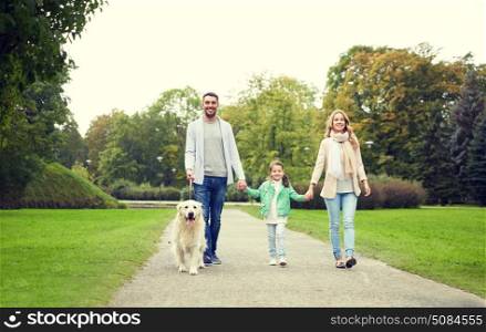 family, pet, domestic animal and people concept - happy family with labrador retriever dog walking in summer park. happy family with labrador retriever dog in park. happy family with labrador retriever dog in park