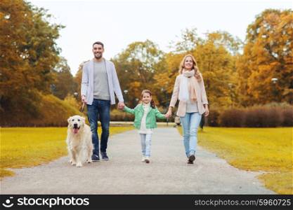 family, pet, domestic animal, season and people concept - happy family with labrador retriever dog walking in autumn park