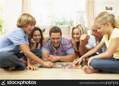 Family Playing Board Game At Home With Grandparents Watching