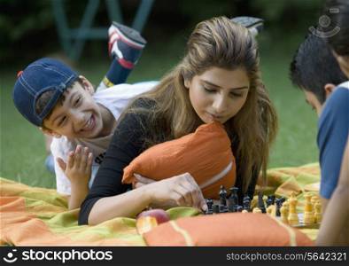 Family playing chess at picnic